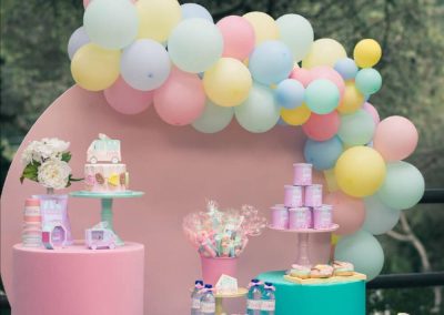 Mesa dulce de fiesta infantil decorada en tonos pastel con globos, dulces y detalles personalizados para Carlota