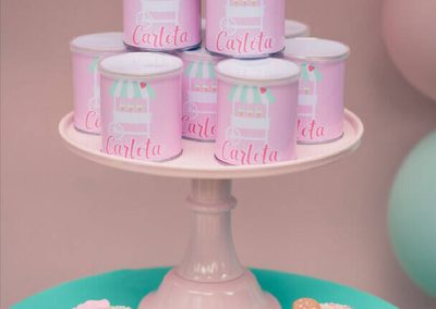 Botes personalizados con el nombre de Carlota y donuts decorados en tonos pastel para una fiesta infantil